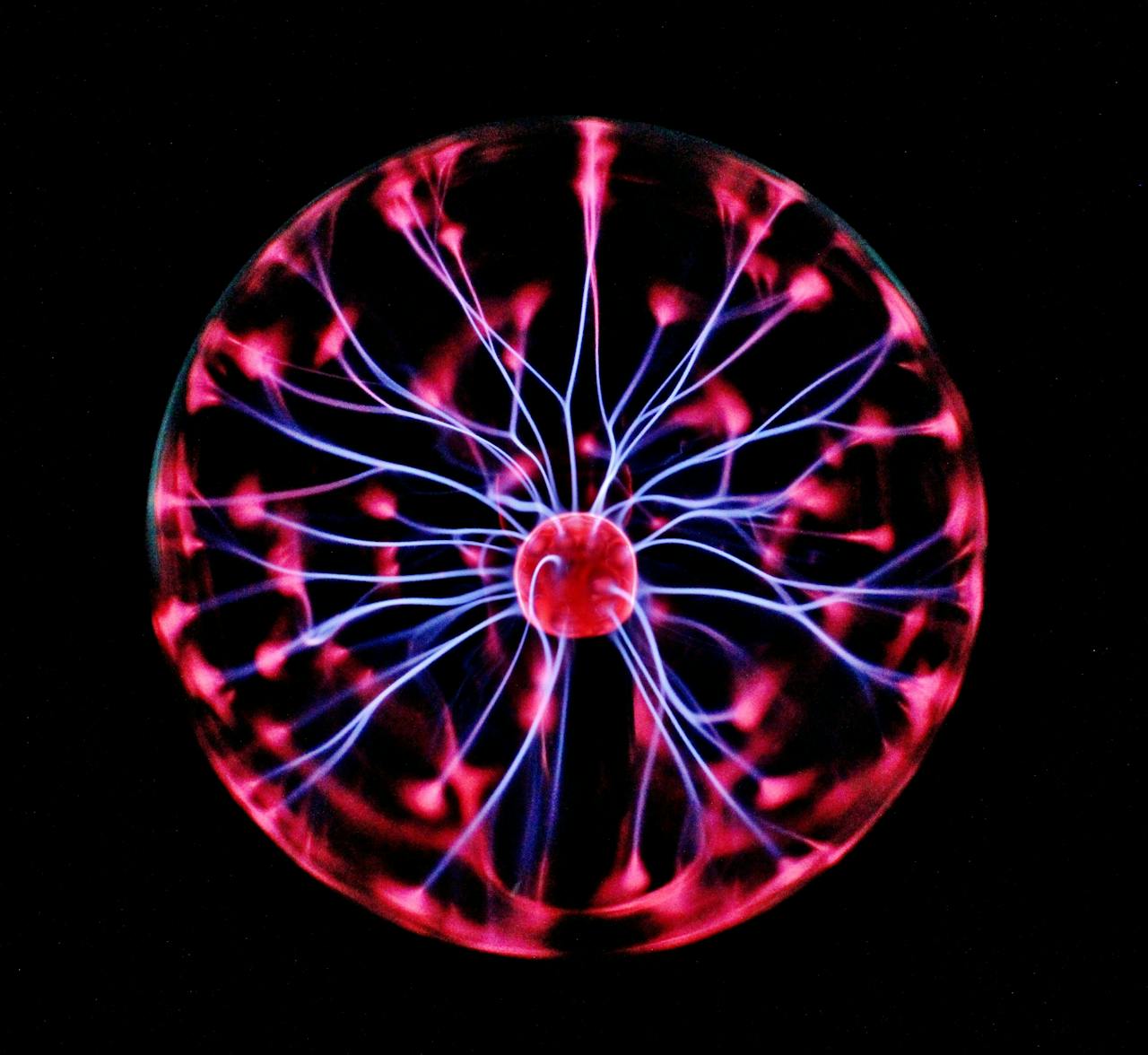 get-in-touch Close-up of a plasma globe with vibrant neon sparks against a dark background.
